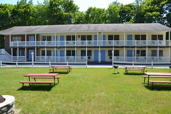 picnic tables in front of 2 story motel units