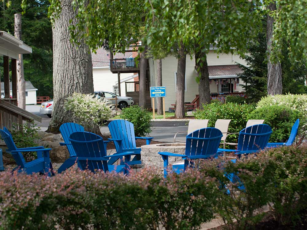 blue Adirondack chairs around stone firepit