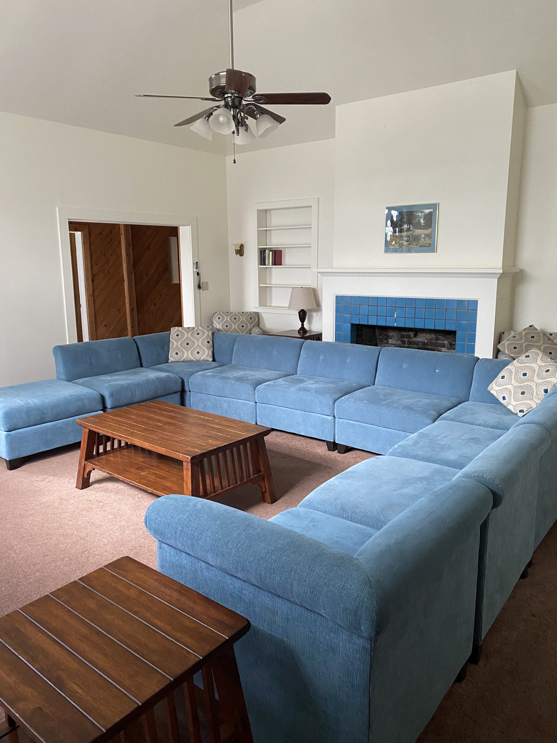 living room sectional with coffee tables and ceiling fan